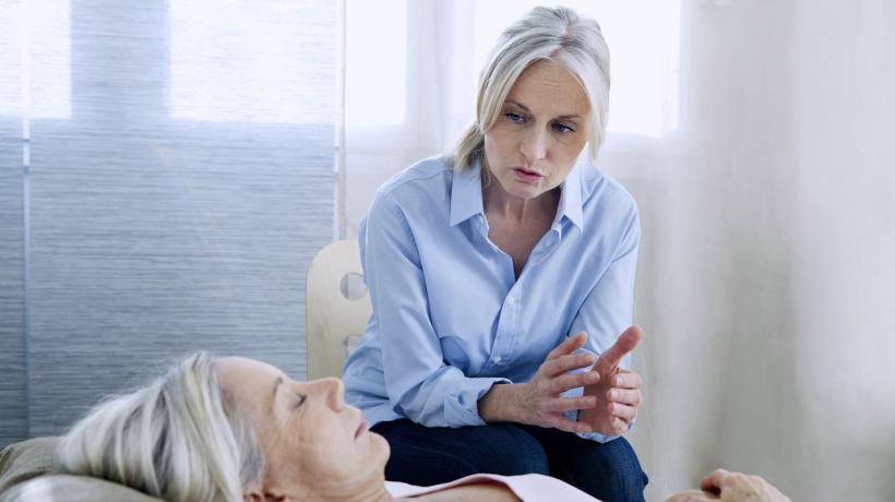 Zwei Frauen im psychotherapeutischen Gespräch. Die Patientin liegt auf der Couch, die Therapeutin sitzt neben ihr.